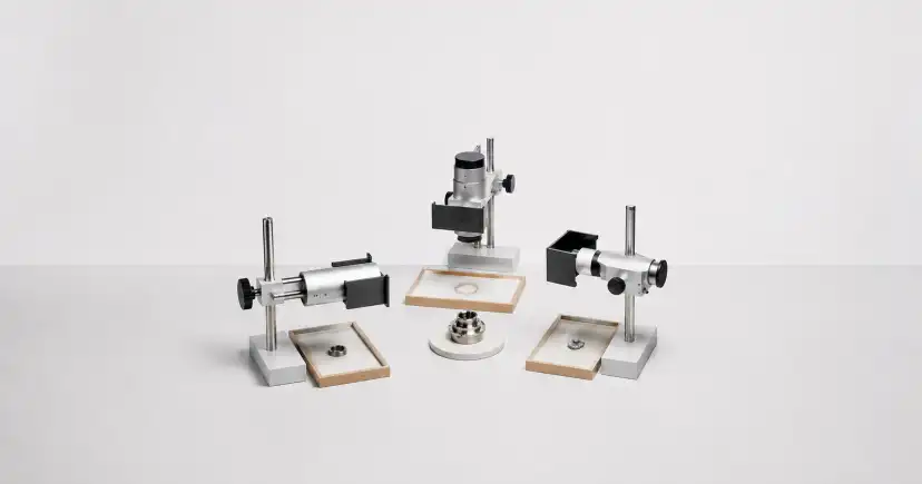 Tres instrumentos ópticos de laboratorio, con lentes y soportes, dispuestos alrededor de portamuestras.