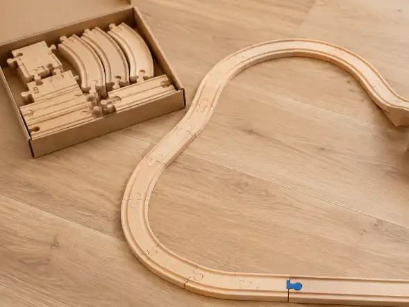 Pista modular de madera que forma un circuito con desvíos y un puente, con un vagón sobre un tramo.
