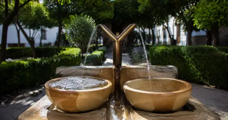Una fuente en forma de Y divide el agua y la dirige hacia dos recipientes separados.