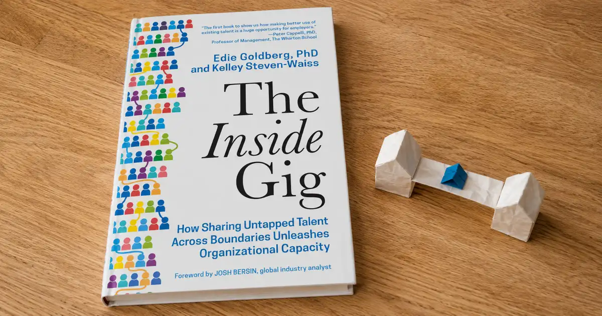 Portada de The Inside Gig sobre una mesa de madera, junto a piezas de papel blancas y azules conectadas.